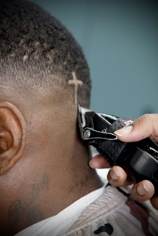 Cross design carved into a fresh fade